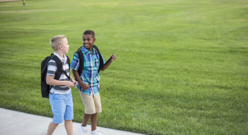Two friendly students in deep conversation on a walk